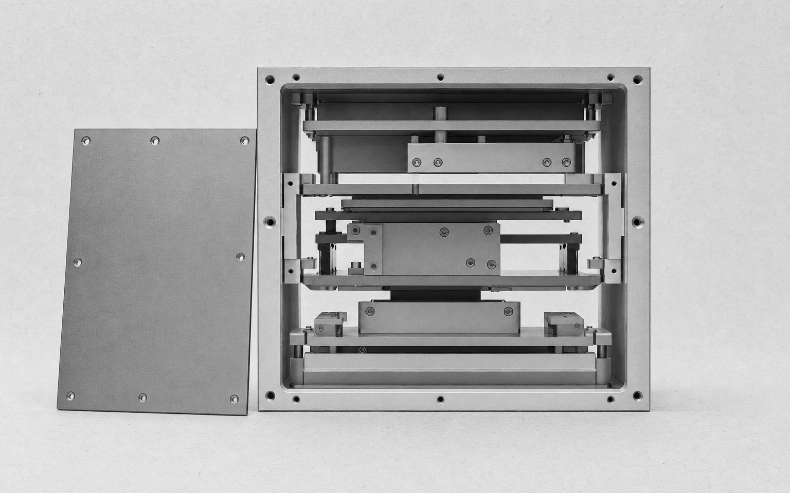 A machined equipment housing with the front panel taken off, so the ordered structure inside is visible.